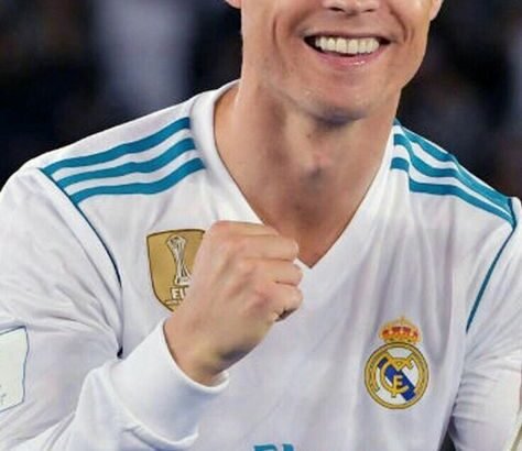 "Cristiano Ronaldo smiling and waving to fans during a match, wearing his iconic football jersey, representing one of the greatest footballers of all time."